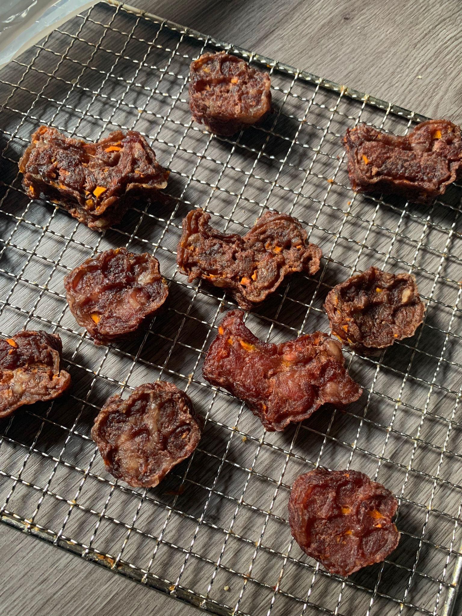 Dark meat chips with carrot flecks on a wire rack